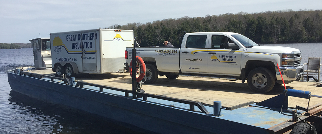 A GNI pick-up and production trailer prepare to unload from a barge for a water-access jobsite.