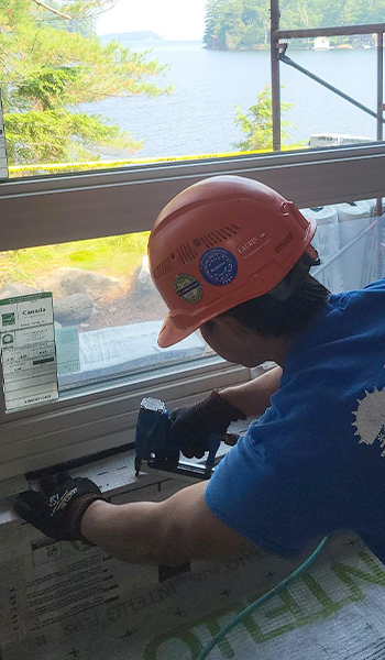 A Great Northern Insulation employee preps a cottage for cellulose insulation install in the exterior walls